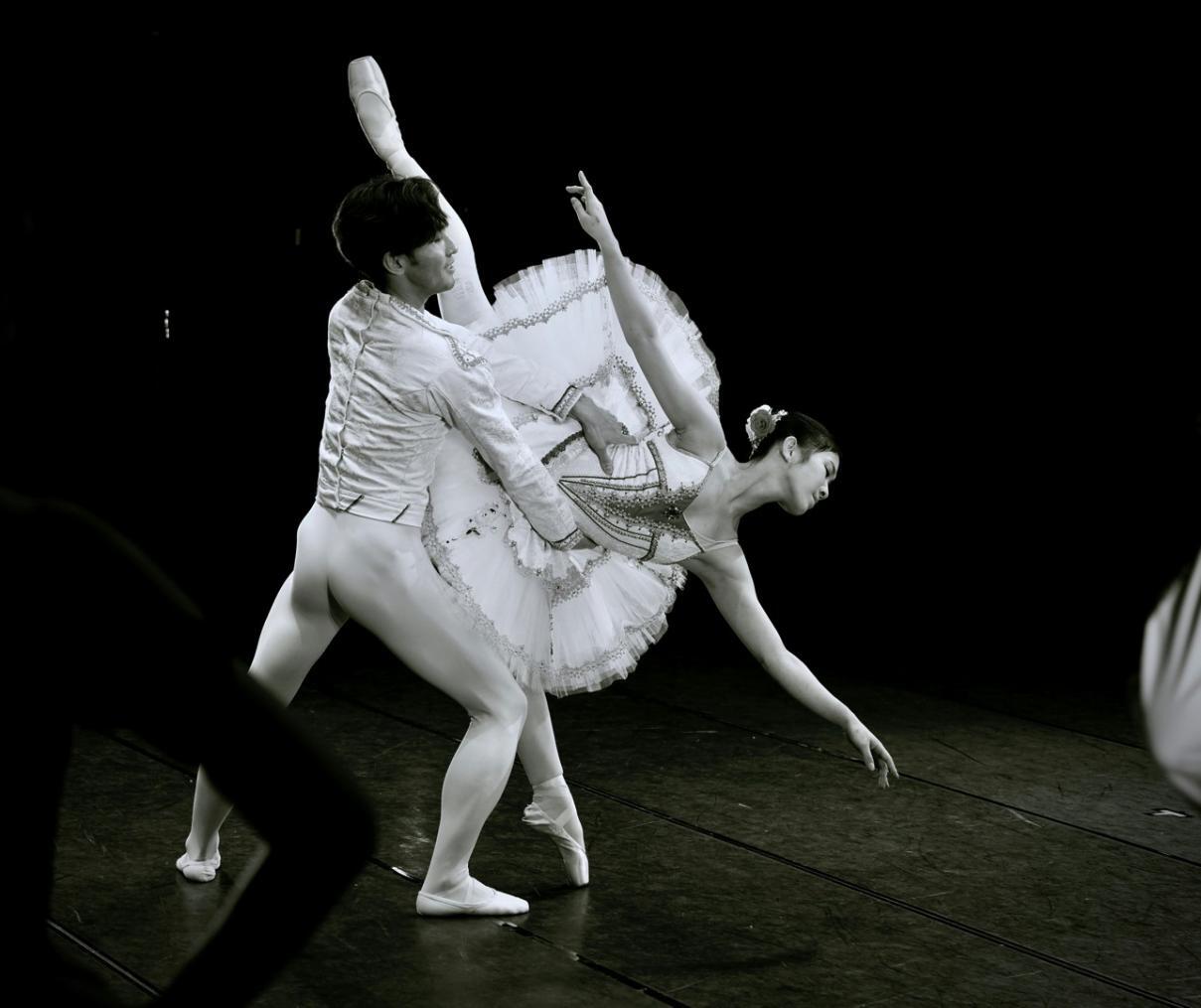 Lezione di balletto con bambine in tutù rosa che praticano alla sbarra